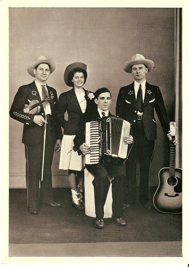 Item #032740 LARGE REAL-PHOTO POSTCARD, SHOWING DOC WILLIAMS, HIS WIFE CHICKIE, BROTHER CY, AND MARION MARTIN:; On-stage in western garb, with their guitar, fiddle and accordion. Doc Williams.